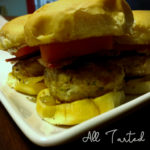 Assembled burgers with bacon, bleu cheese sauce, onions, and tomato